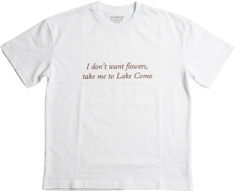 T-shirt blanc oversize, avec la phrase « I don't want flowers, take me to Lake Como » imprimée en italique bordeaux.